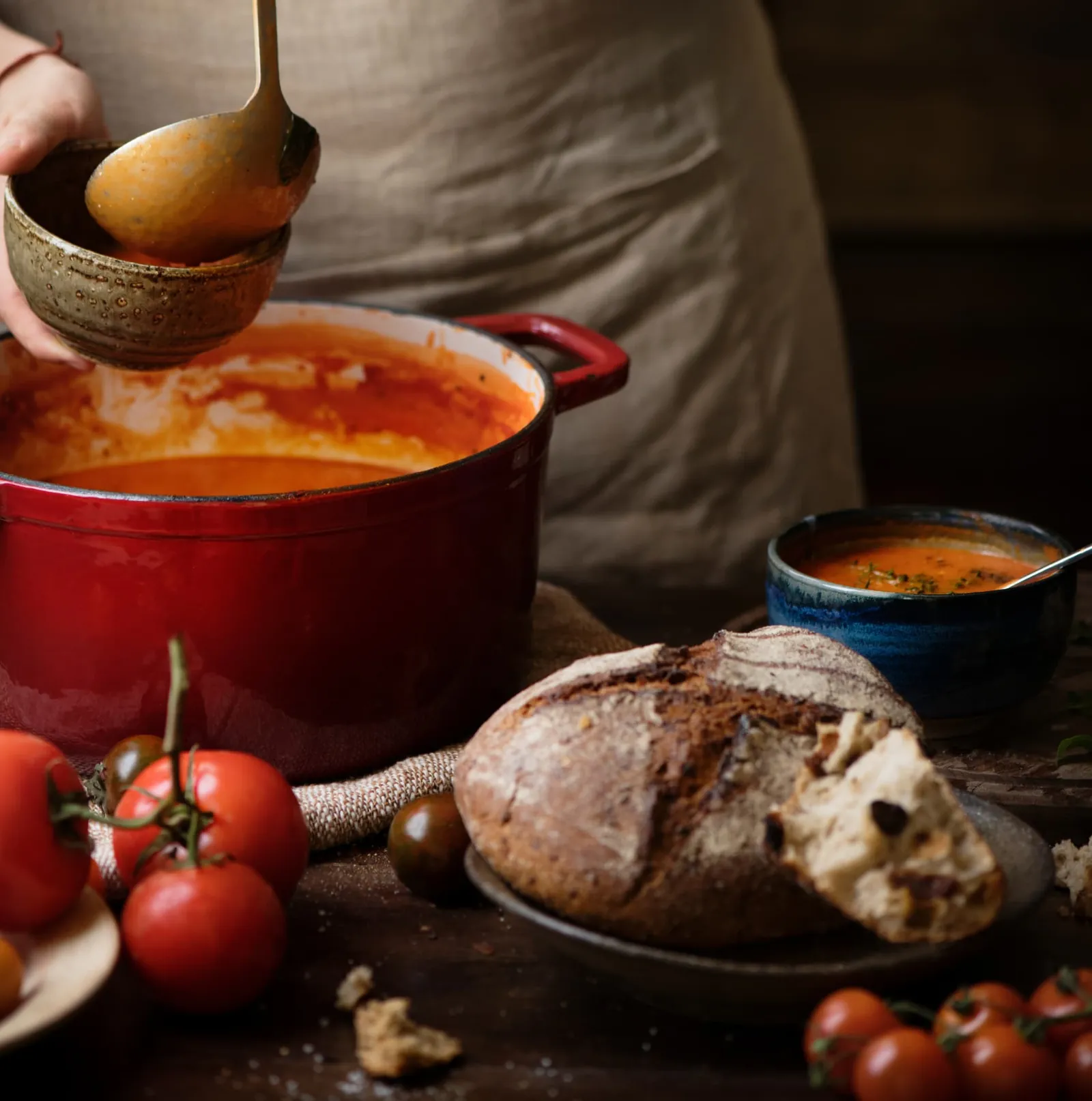 Homemade tomato soup with rustic bread and fresh tomatoes